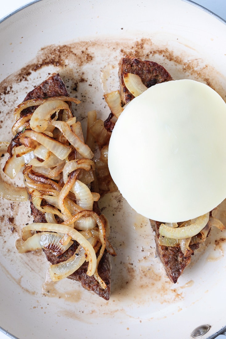 meatloaf slices in skillet with onions and cheese