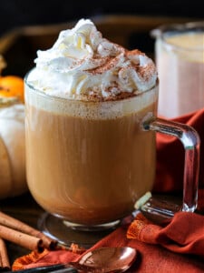 coffee in a glass mug with whipped cream and pumpkin spice creamer