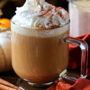 coffee in a glass mug with whipped cream and pumpkin spice creamer