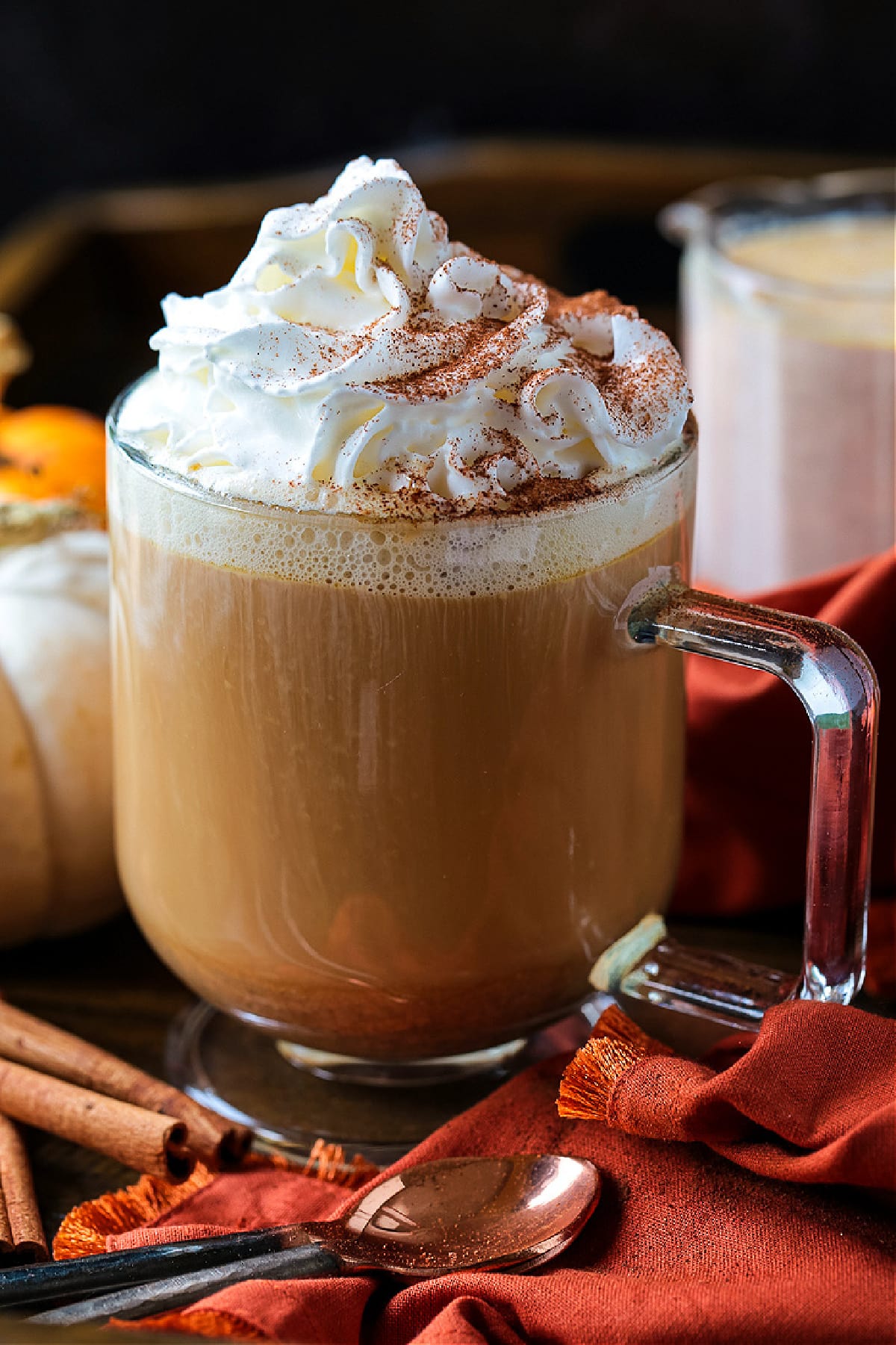 coffee in a glass mug with whipped cream and pumpkin spice creamer