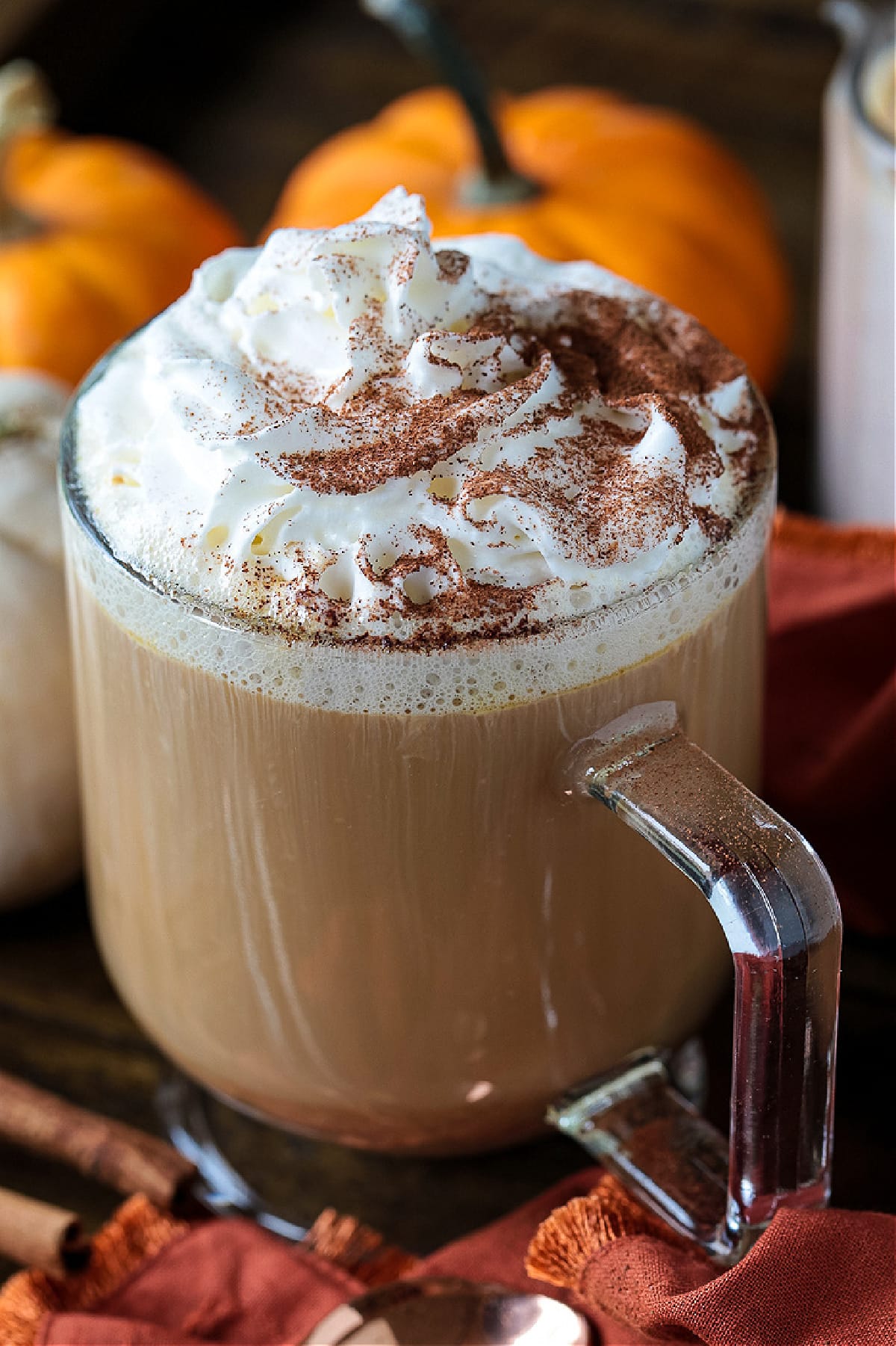 glass coffee mug with coffee and whipped cream on top