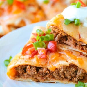 mexican pizza cut and stacked on plate with toppings