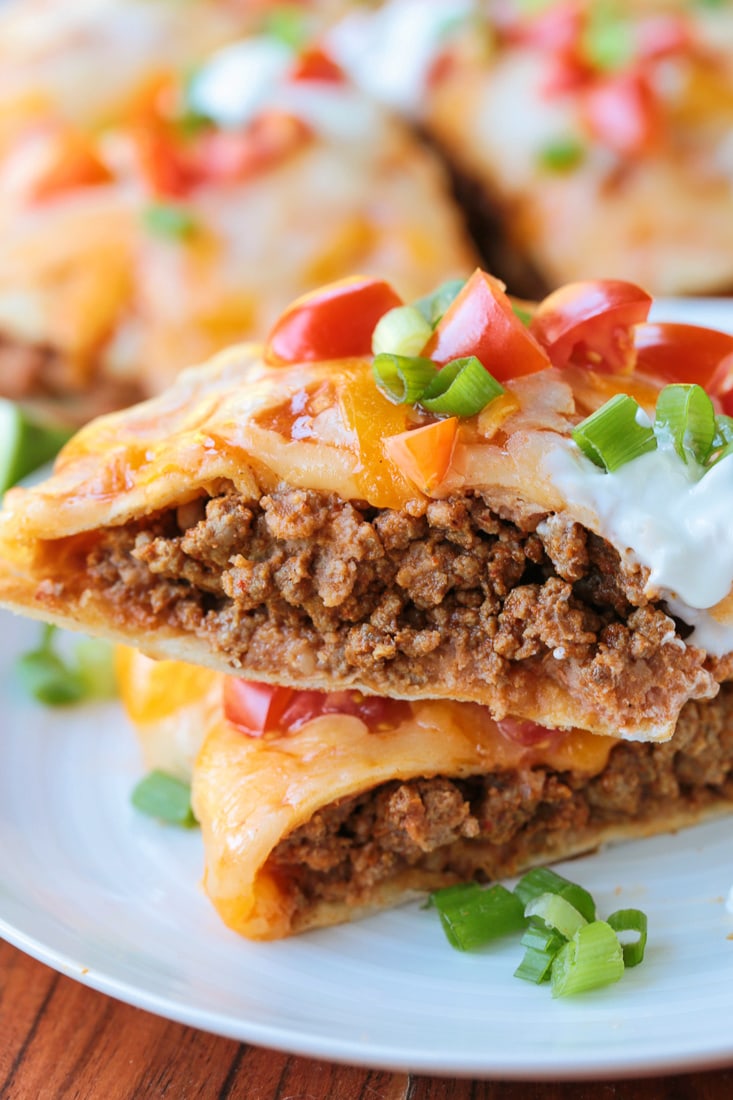 slice of mexican pizza stacked on plate with toppings