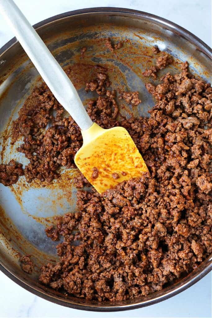 seasoned ground beef in skillet with spatula