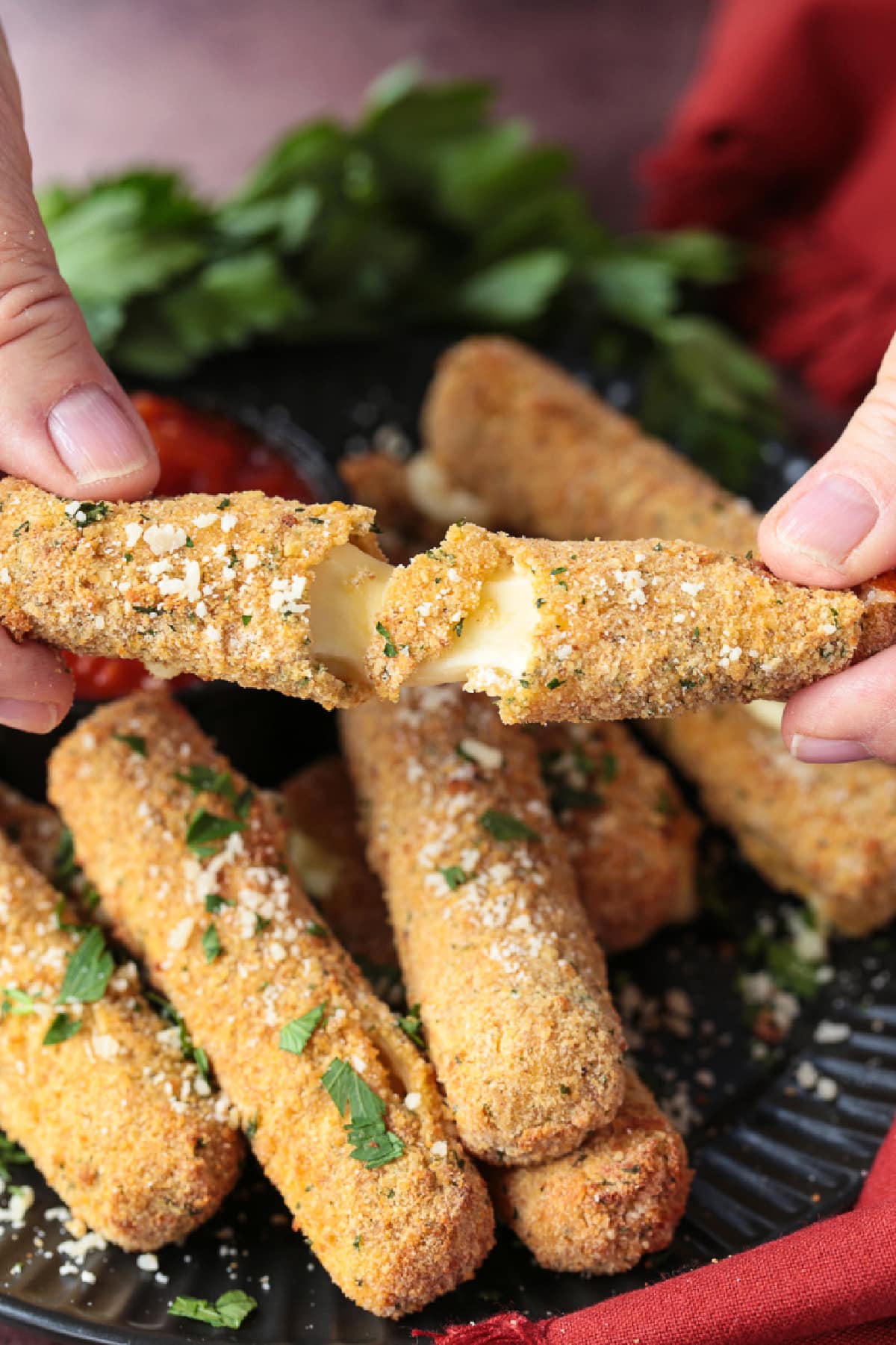 Air Fryer Mozzarella Sticks turn out fabulously crispy without any oil! Brown and crispy on the outside and cheese-pull worthy on the inside! mozzarella stick being pulled apart
