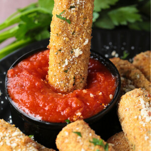 mozzarella stick being dipped into sauce