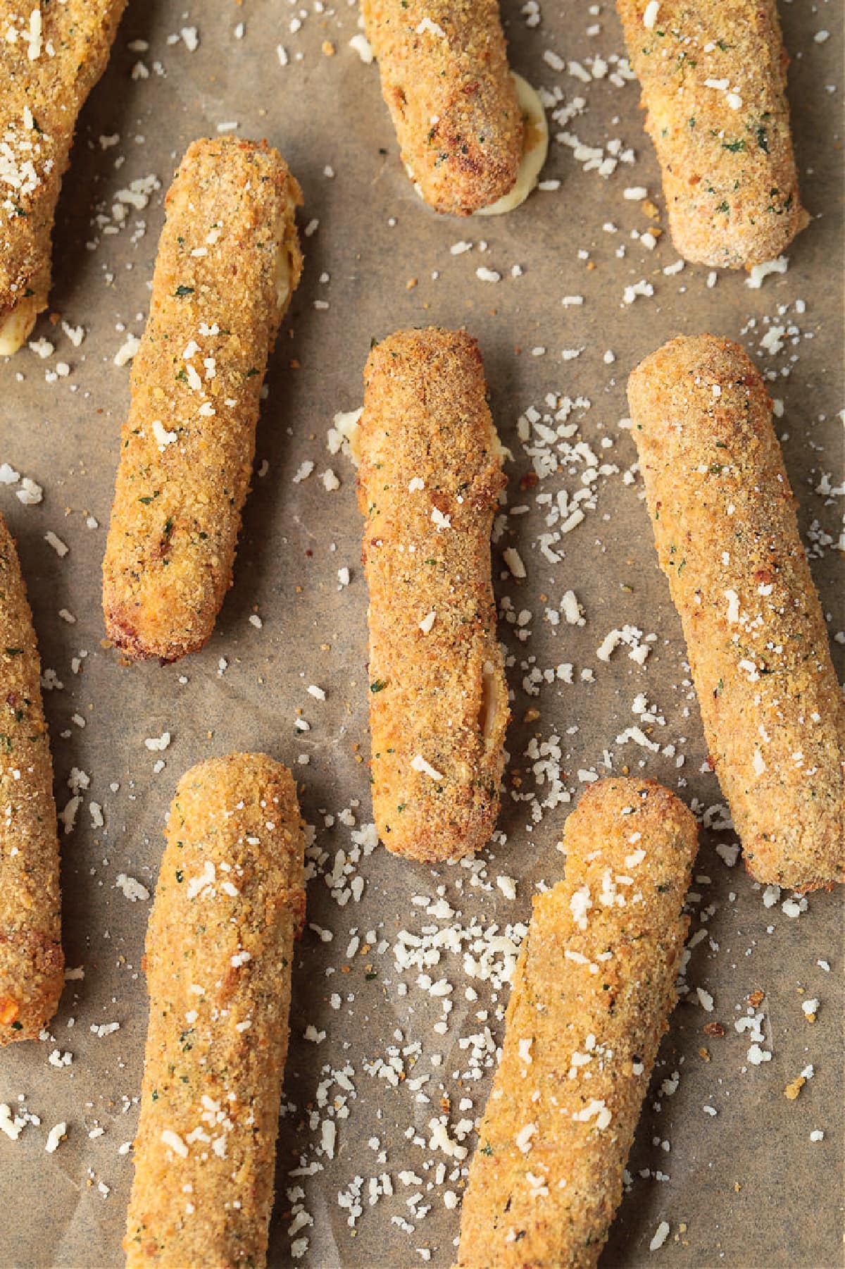 Air Fryer Mozzarella Sticks turn out fabulously crispy without any oil! Brown and crispy on the outside and cheese-pull worthy on the inside! air fryer mozzarella sticks on parchment