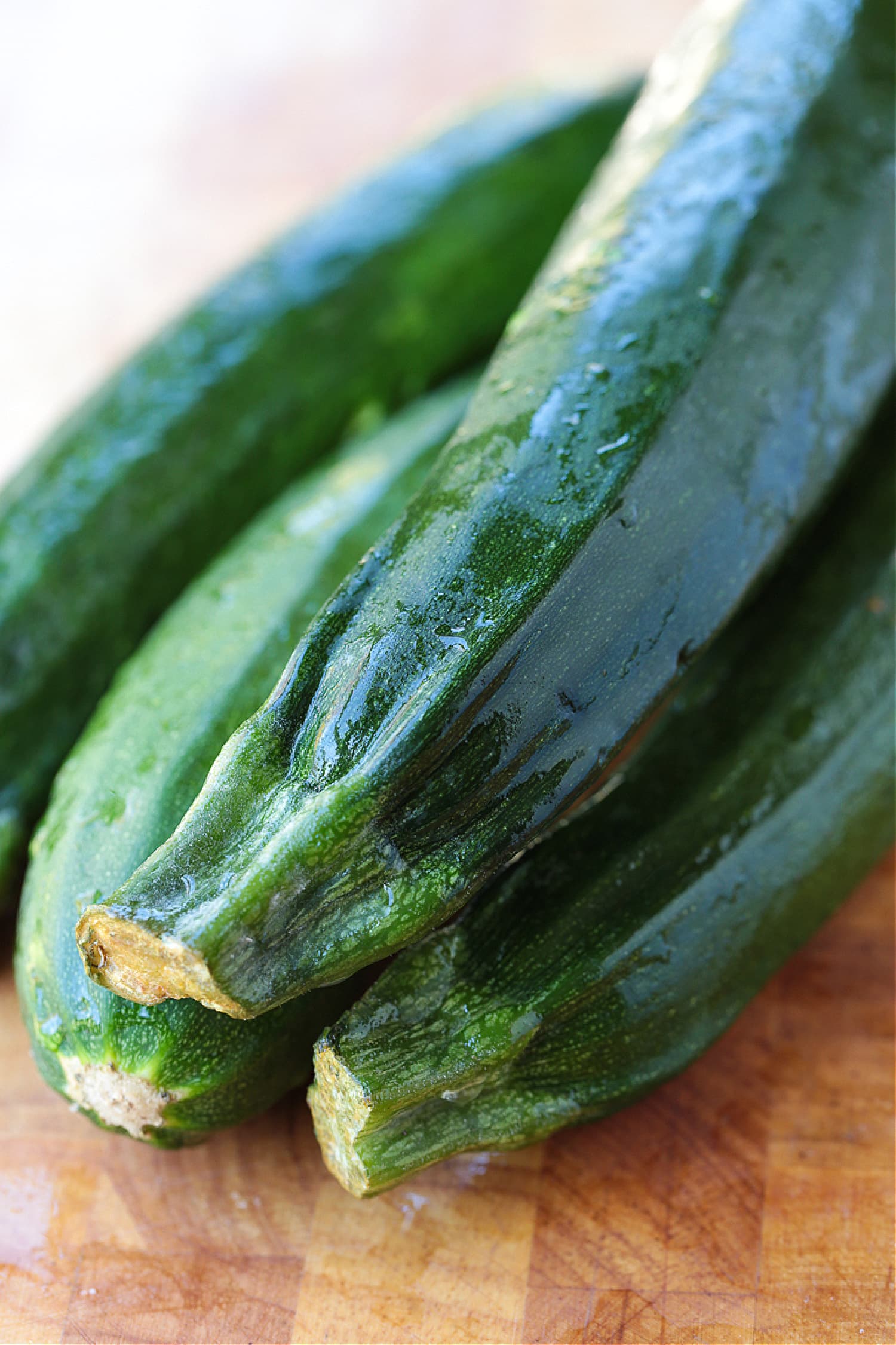 Four raw zucchinis in a pile