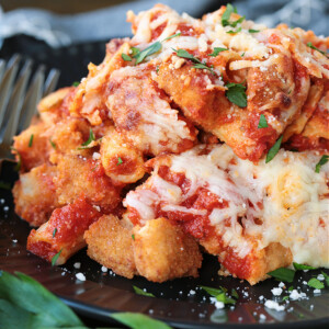 Chicken and pasta casserole on a black plate with fork