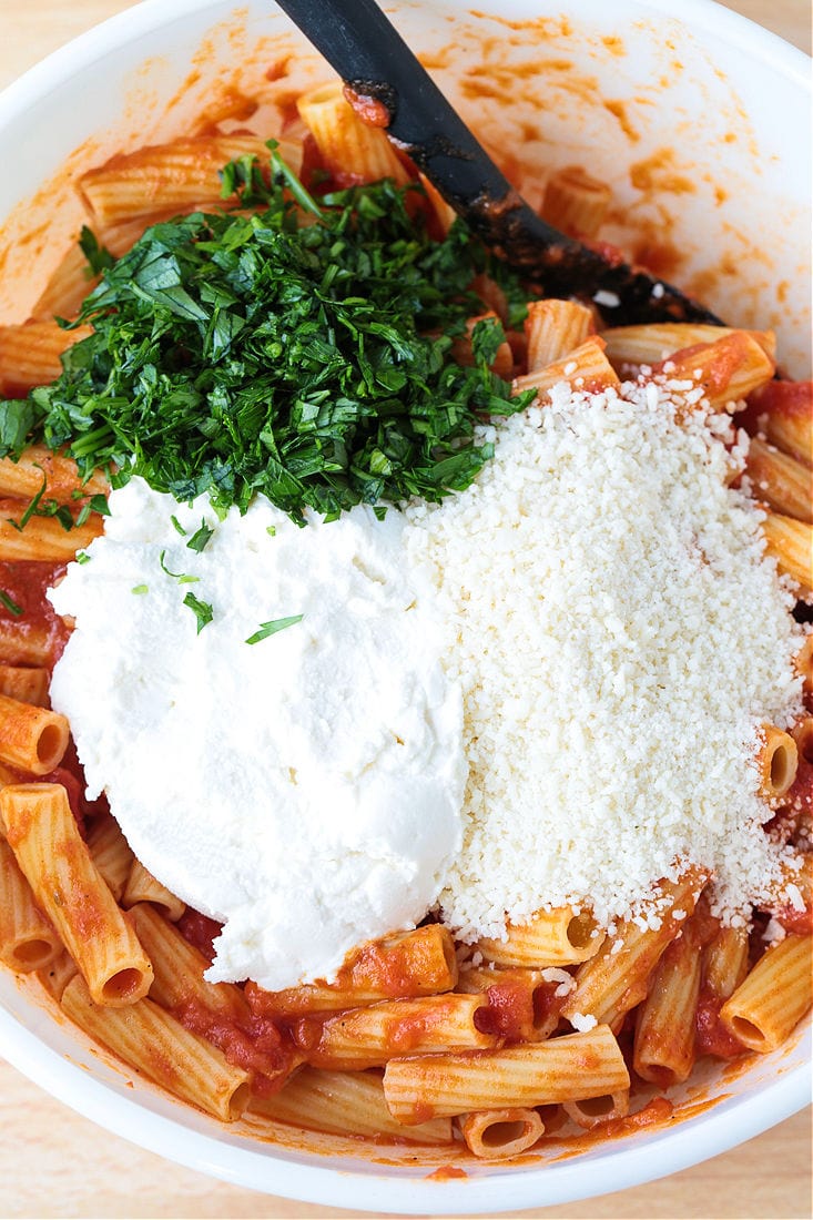 ziti with parsley, ricotta and parmesan cheese in a bowl