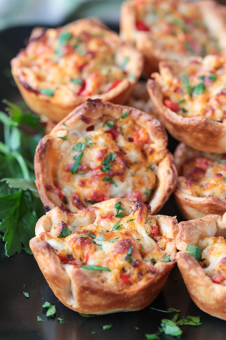 crab puffs on black platter with parsley