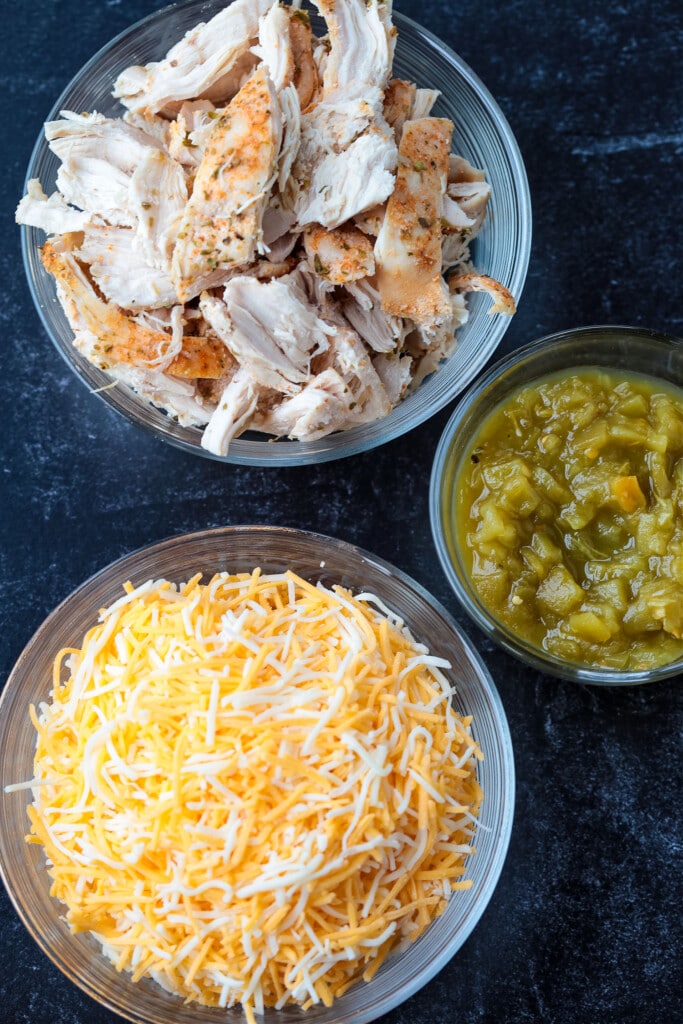 shredded chicken, green chilis and cheese on a black board