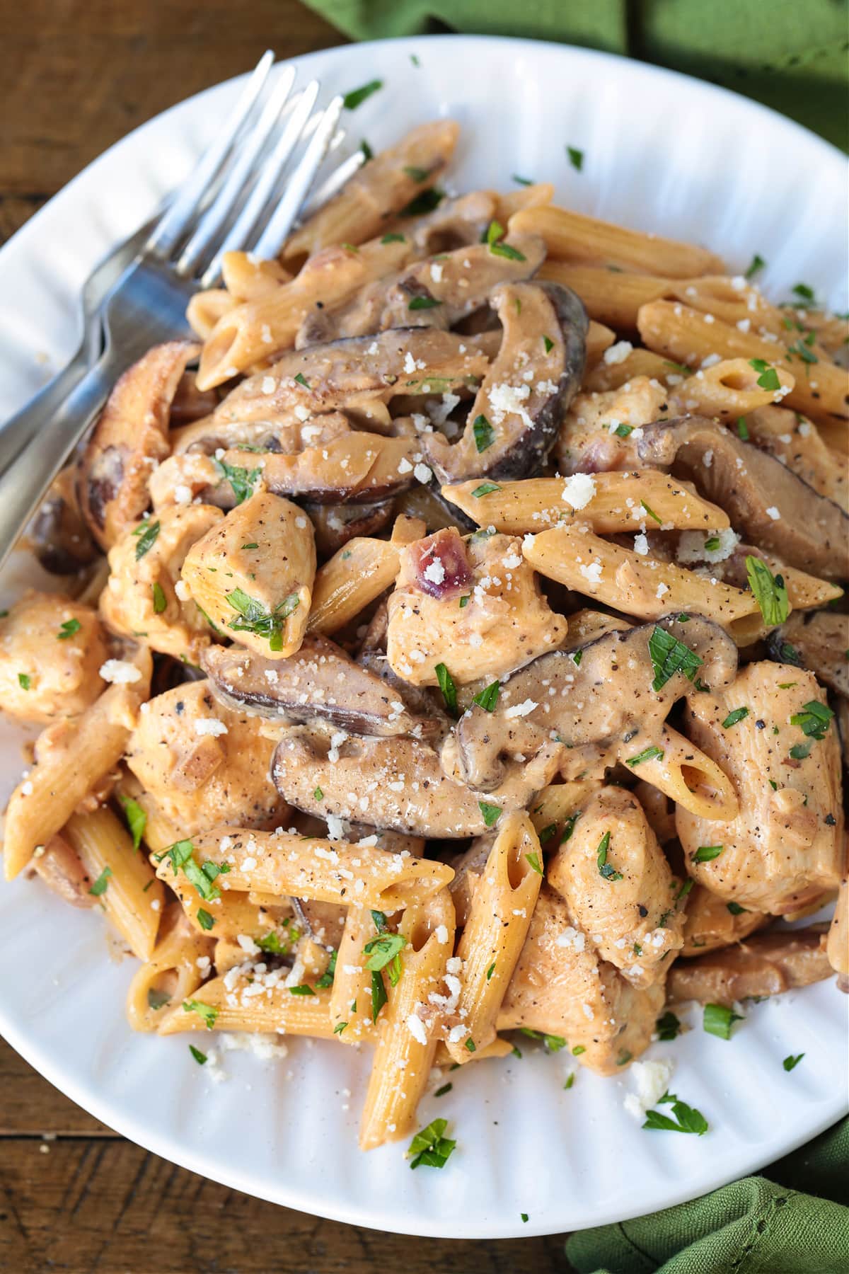 Our Pasta Da Vinci is a dead on copycat of the Cheesecake Factory recipe! Penne in a creamy wine sauce, juicy chicken, and hearty mushrooms. pasta da vinci on a white plate with fork