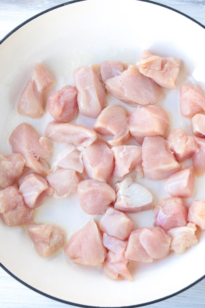 diced raw chicken in a skillet