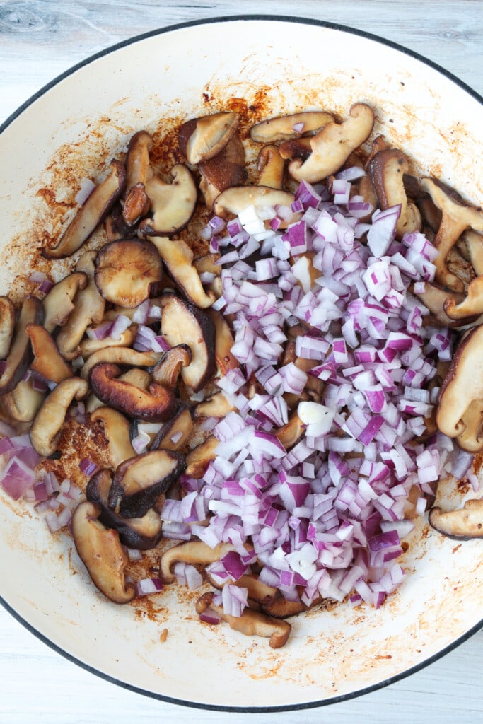 Our Pasta Da Vinci is a dead on copycat of the Cheesecake Factory recipe! Penne in a creamy wine sauce, juicy chicken, and hearty mushrooms. browned mushrooms in a skillet with diced red onion