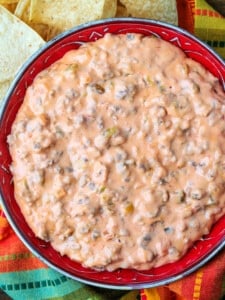 sausage cheese dip in bowl with chips on the side