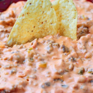 sausage cheese dip with chips dipped in