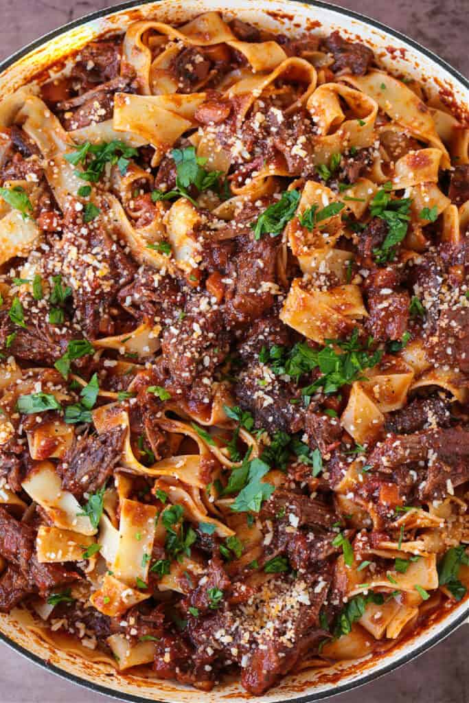 pot with pasta and short rib ragu topped with parsley