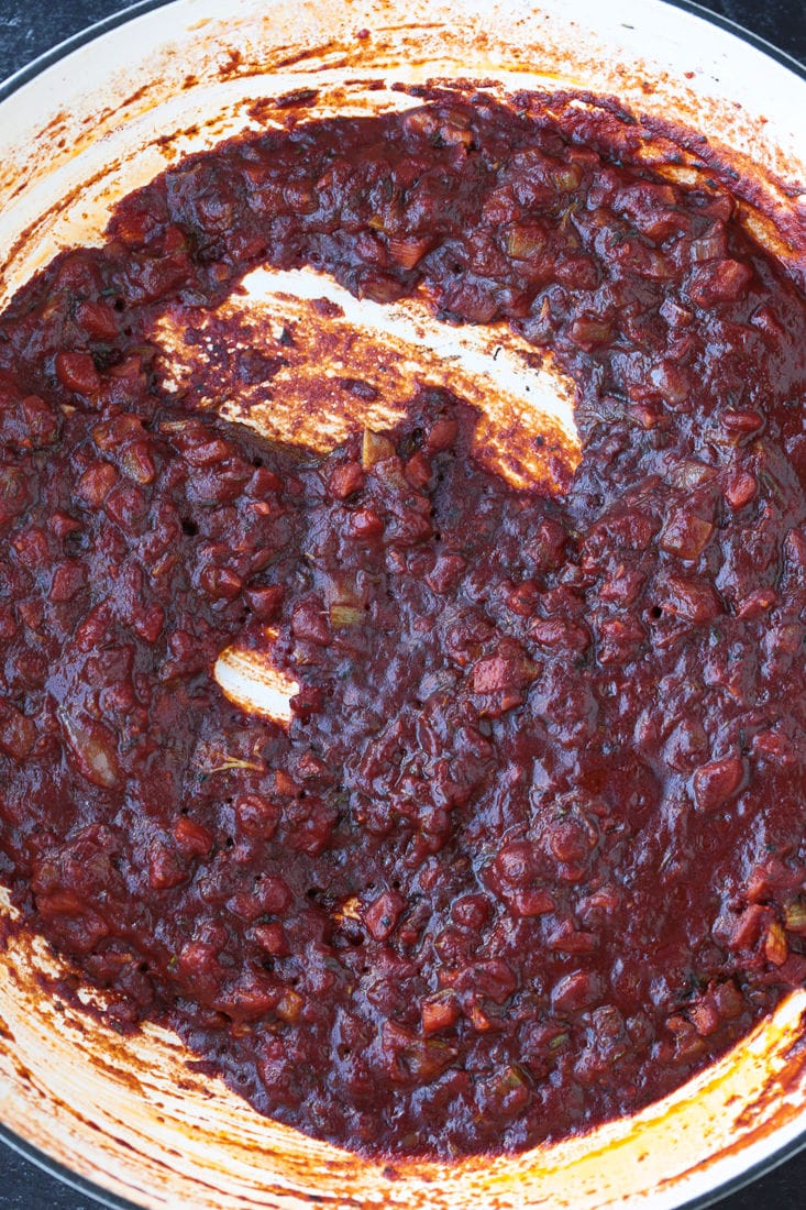 A think, wine-colored ragu sauce cooking in a pot.