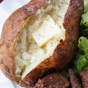 baked potato on plate with butter