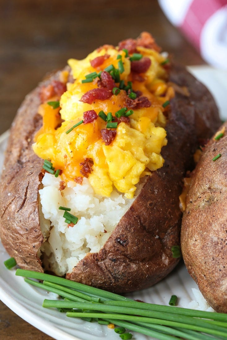 Breakfast Baked Potatoes are stuffed with fluffy scrambled eggs, cheese and crispy bacon! So fun for brunch, breakfast and even dinner! baked potatoes stuffed with eggs, cheese and bacon