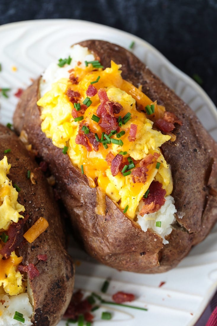 Breakfast Baked Potatoes are stuffed with fluffy scrambled eggs, cheese and crispy bacon! So fun for brunch, breakfast and even dinner! baked potato stuffed with eggs, cheese and bacon
