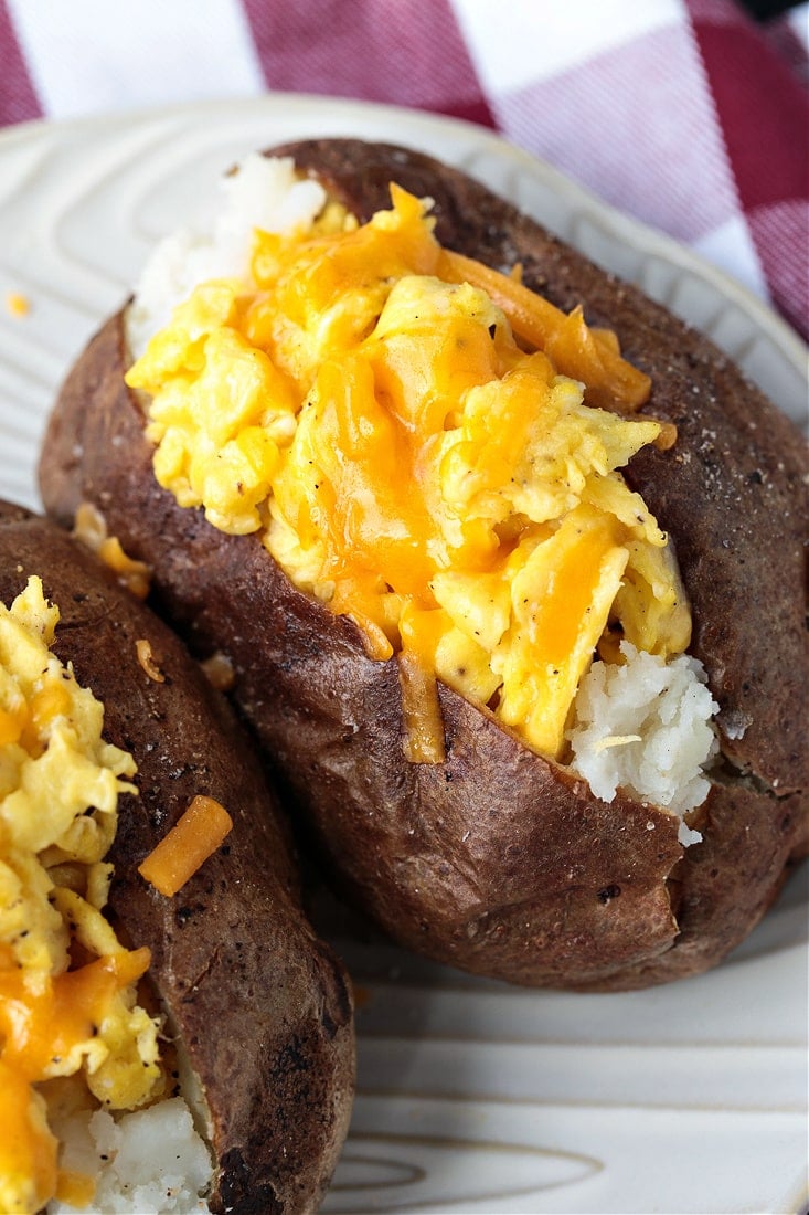 Breakfast Baked Potatoes are stuffed with fluffy scrambled eggs, cheese and crispy bacon! So fun for brunch, breakfast and even dinner! baked potato stuffed with eggs and cheese