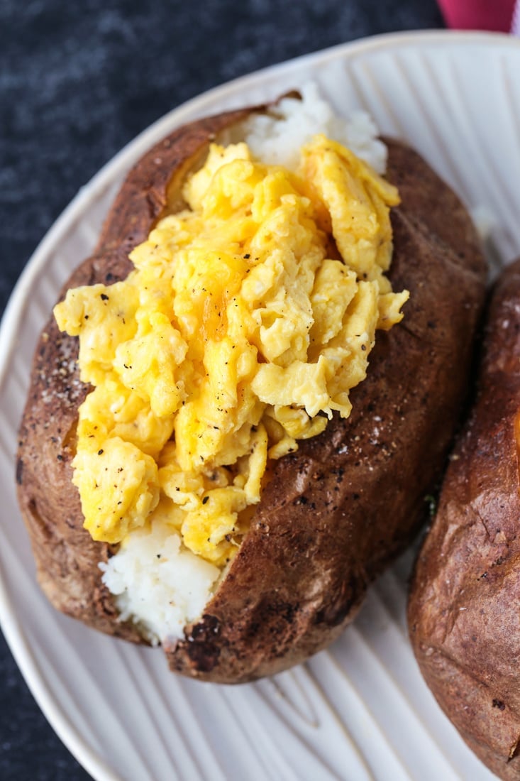 Breakfast Baked Potatoes are stuffed with fluffy scrambled eggs, cheese and crispy bacon! So fun for brunch, breakfast and even dinner! scrambled eggs stuffed into a baked potato