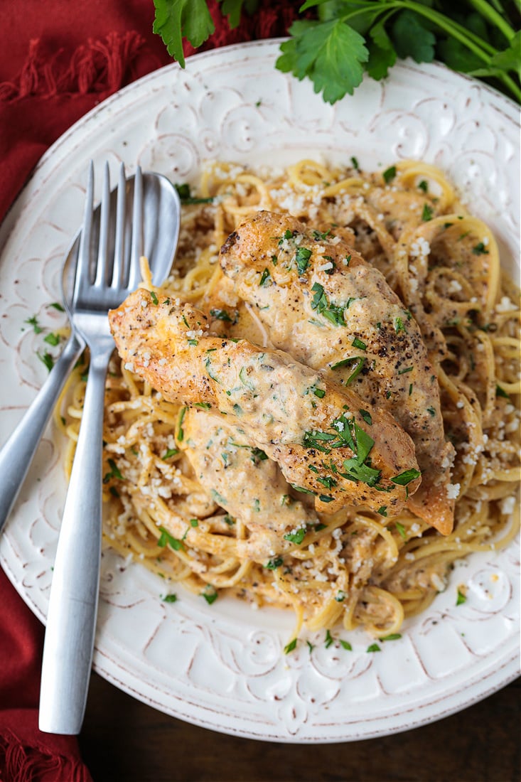 chicken tenderloins in cream sauce on a bed of pasta