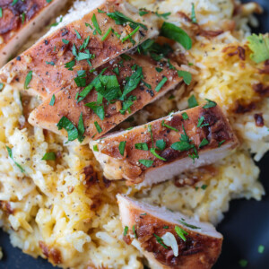 baked chicken breast sliced on a bed of rice