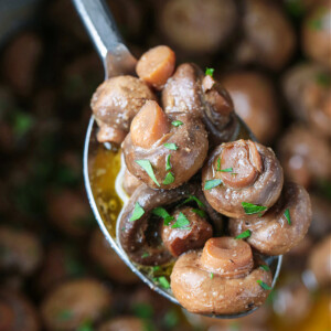 mushrooms cooked in butter and wine on a serving spoon