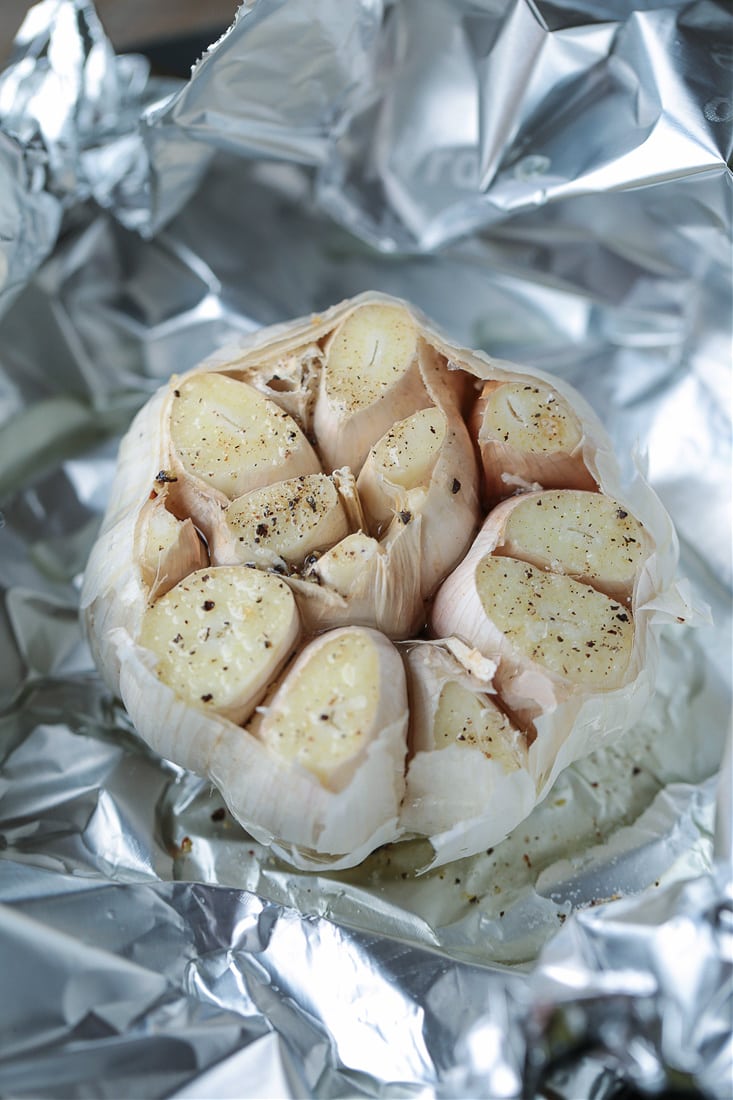 head of garlic with the top cut off and seasoned