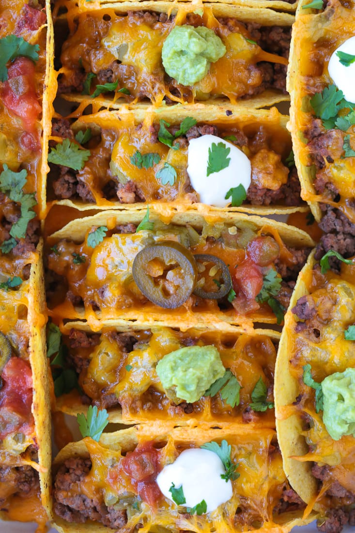 baked tacos in baking dish with toppings