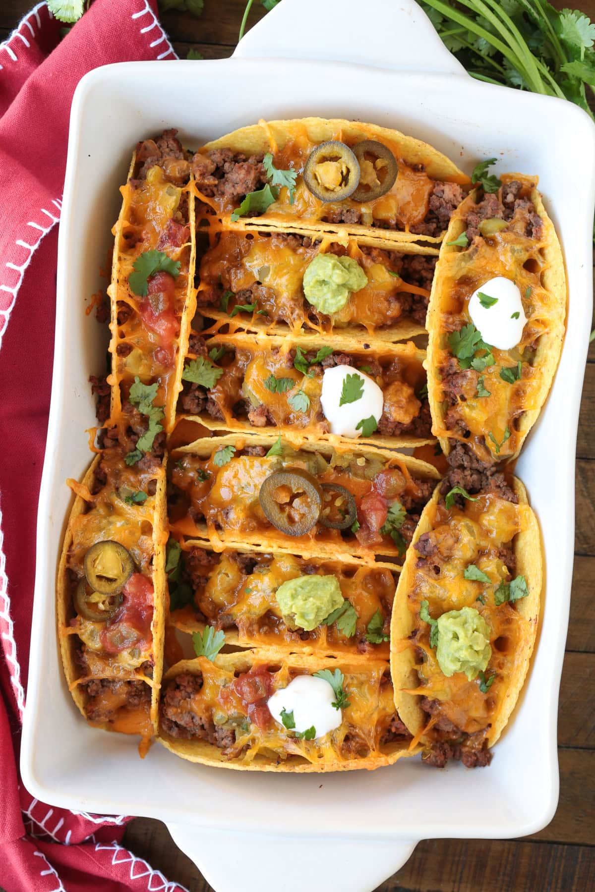 Kick up taco night with these addicting, crispy Baked Tacos! Super easy to make for parties or every day dinners, and everyone loves them! baked tacos in a white baking dish