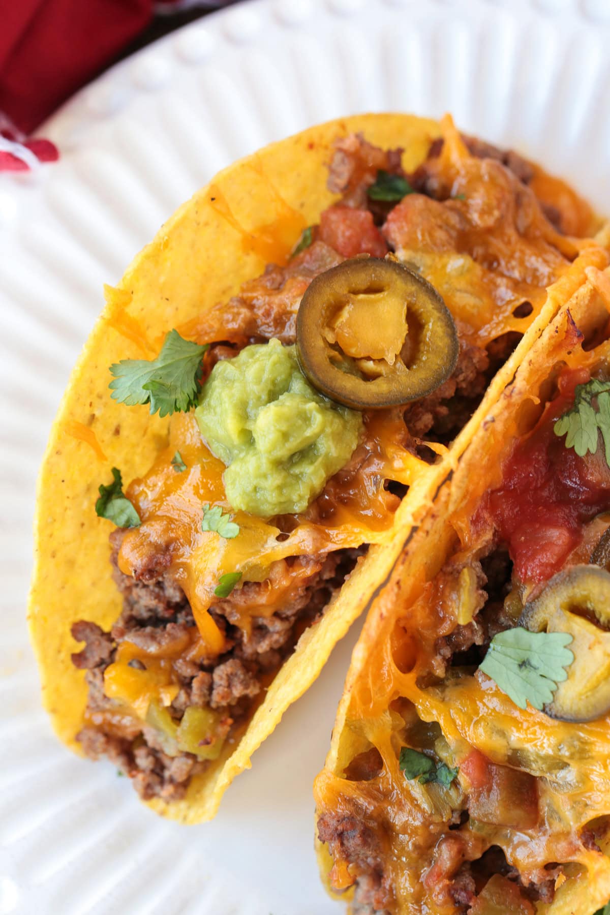 Kick up taco night with these addicting, crispy Baked Tacos! Super easy to make for parties or every day dinners, and everyone loves them! ground beef tacos on white plate with toppings