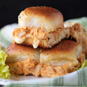 chicken sliders stacked on a plate with melted mozzarella