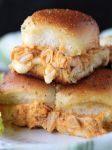 chicken sliders stacked on a plate with melted mozzarella