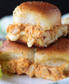 chicken sliders stacked on a plate with melted mozzarella
