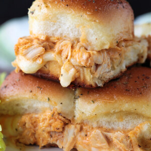 chicken sliders stacked on a plate with melted mozzarella