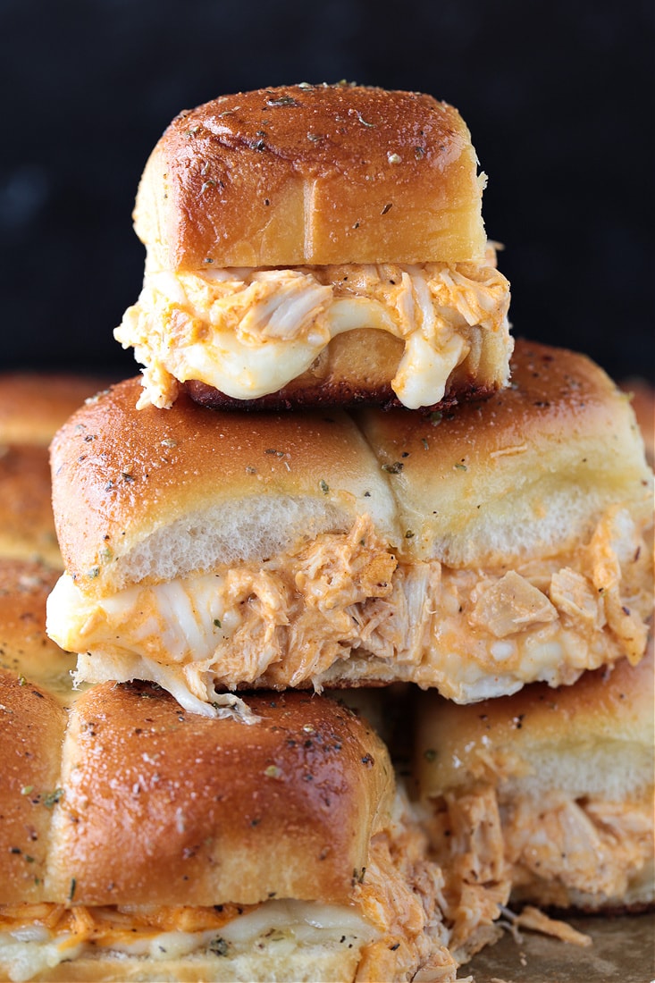 buffalo chicken sliders stacked on a sheet pan