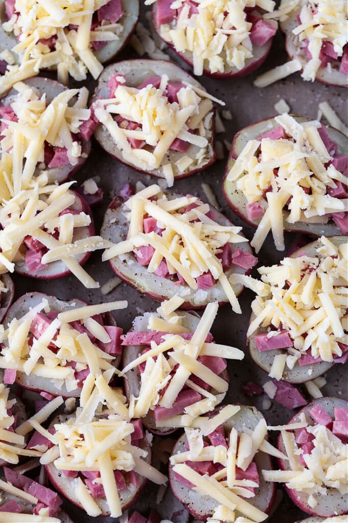 Stuffed potatoes with corned beef and cheese on baking sheet