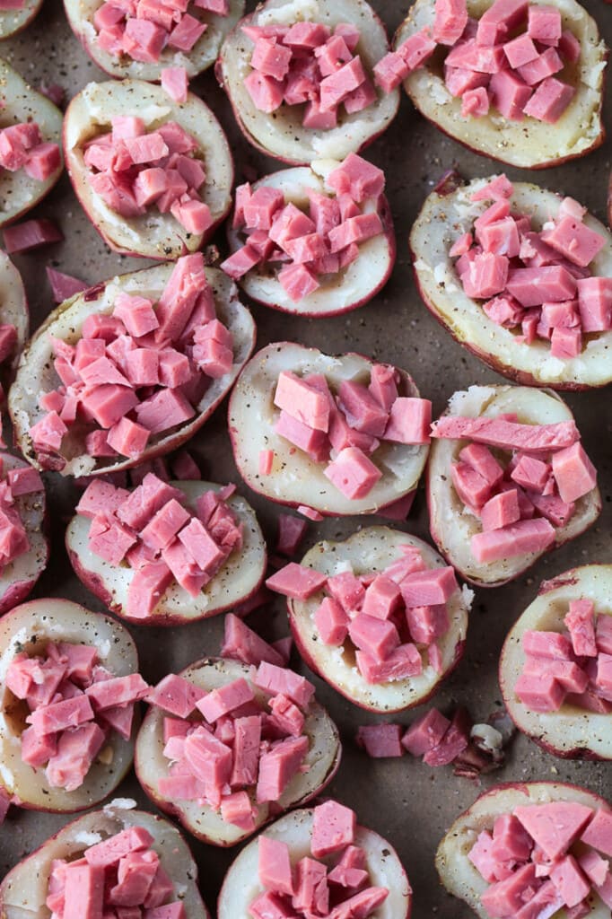 Corned beef stuffed into red potatoes on baking sheet