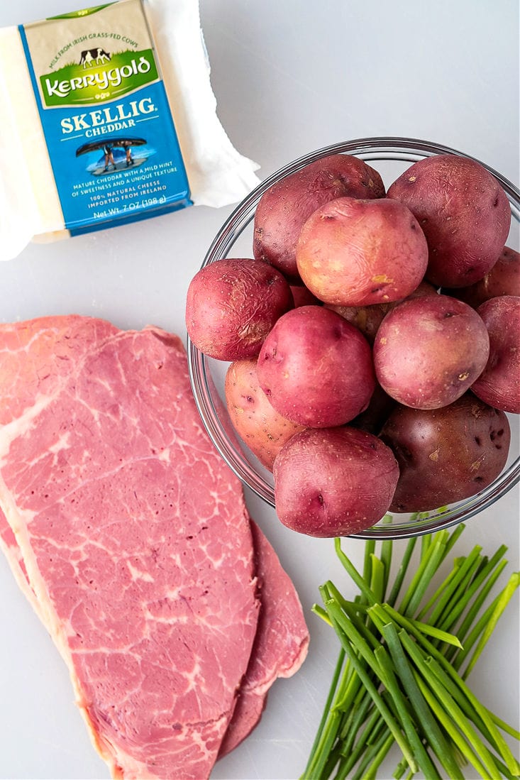 Corned beef, red potatoes, chives and cheddar cheese on board