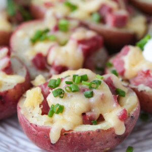 Corned beef stuffed potatoes on platter with chives