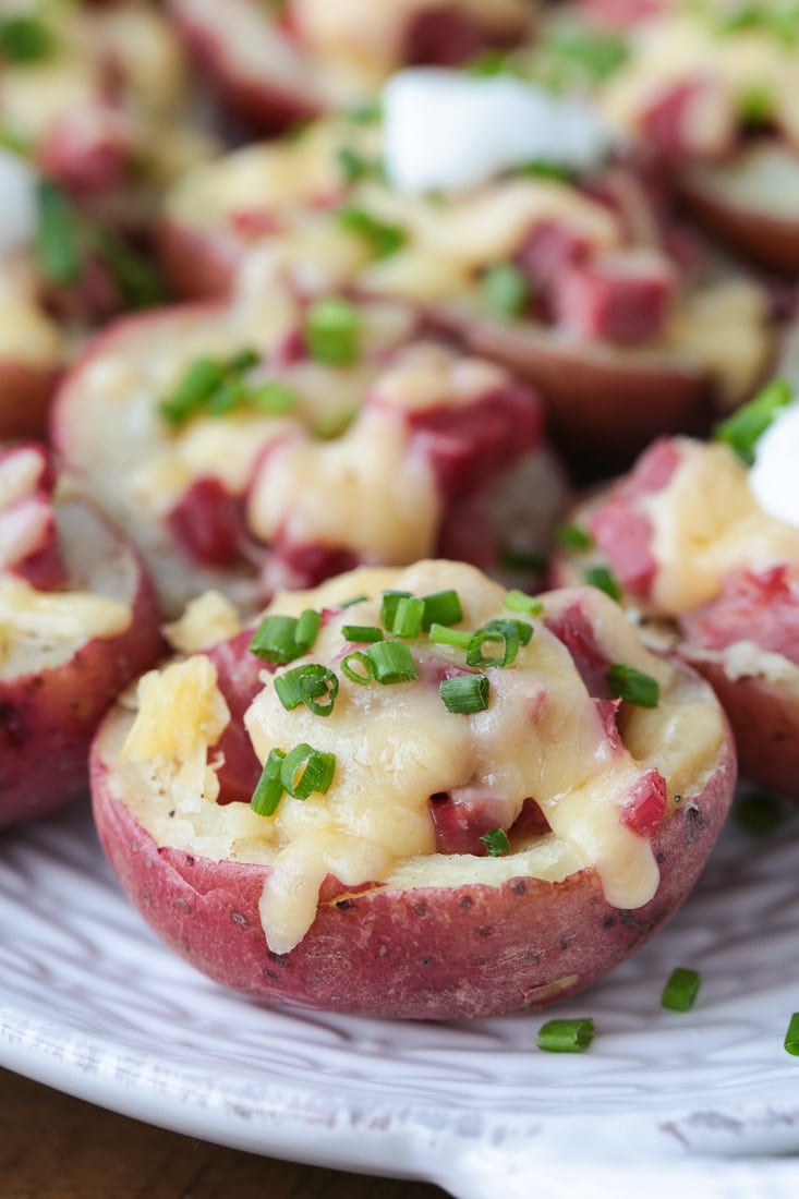 Corned beef stuffed potatoes on platter with chives