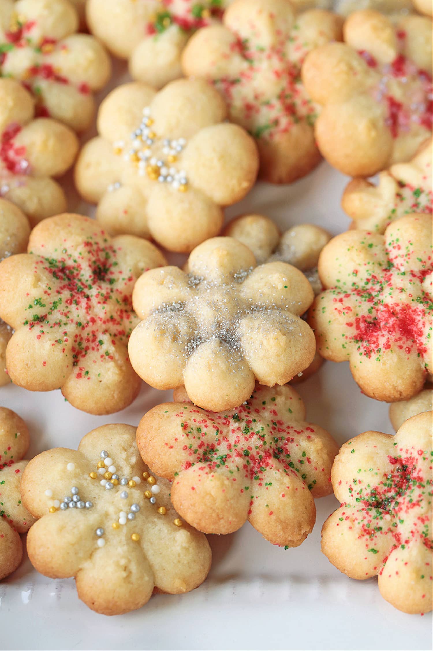 spritz cookies with silver sprinkles on white plate