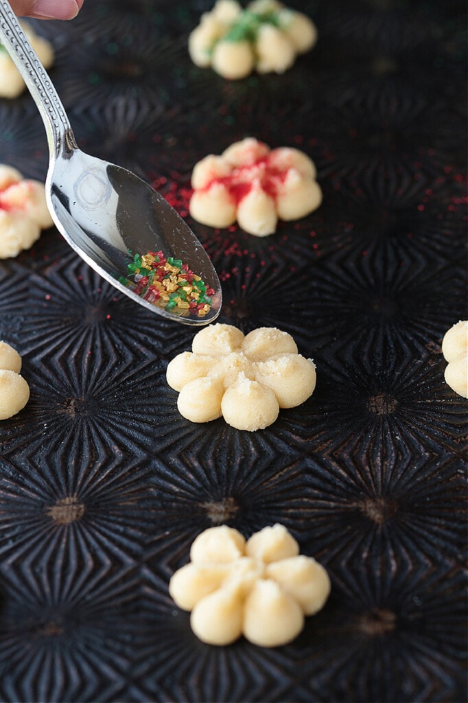 spoon with sprinkles topping a cookie