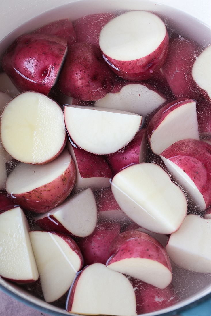 red skin potatoes in pot with water