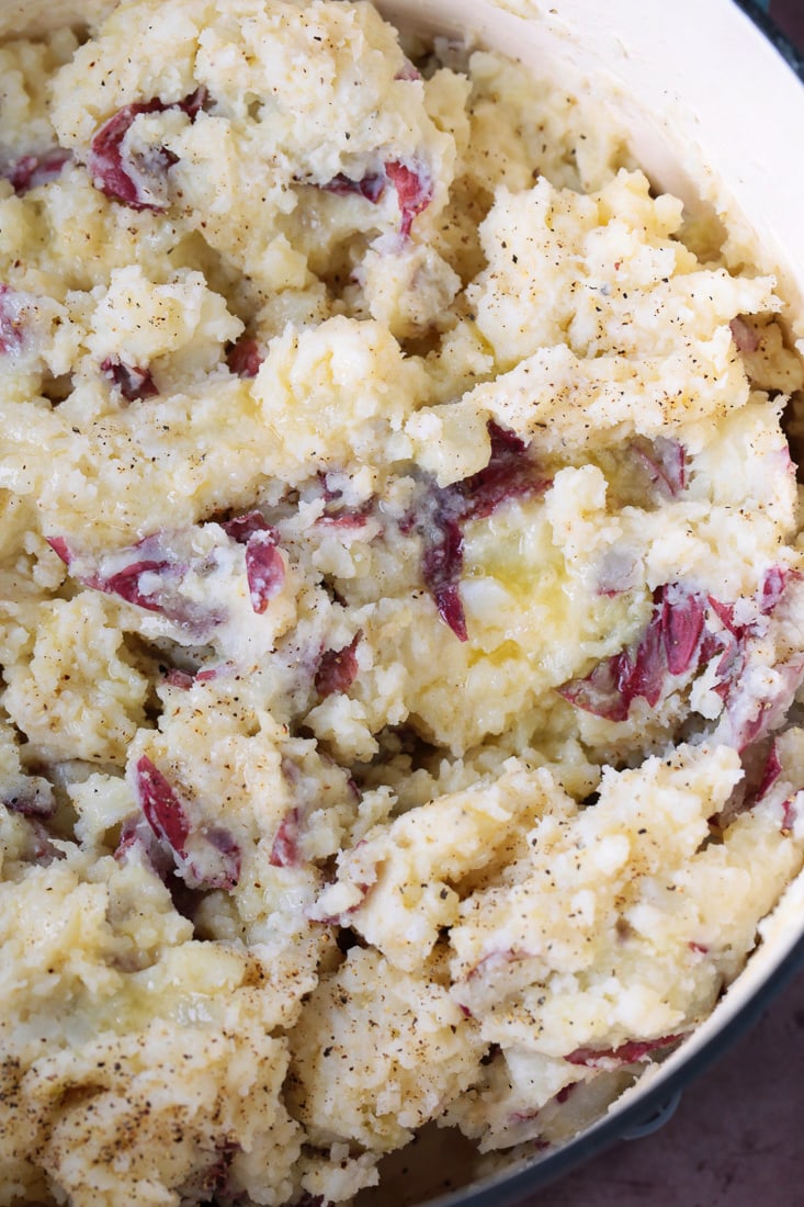 mashed potatoes in pot with butter, salt and pepper