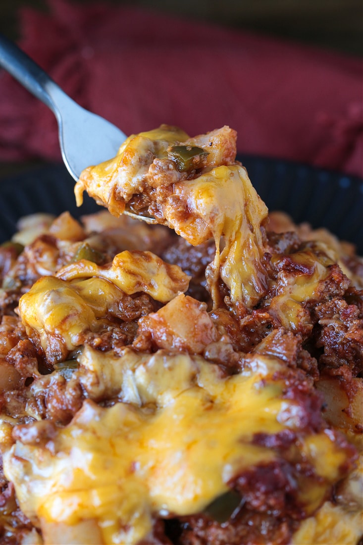 fork lifting bite of casserole with cheese